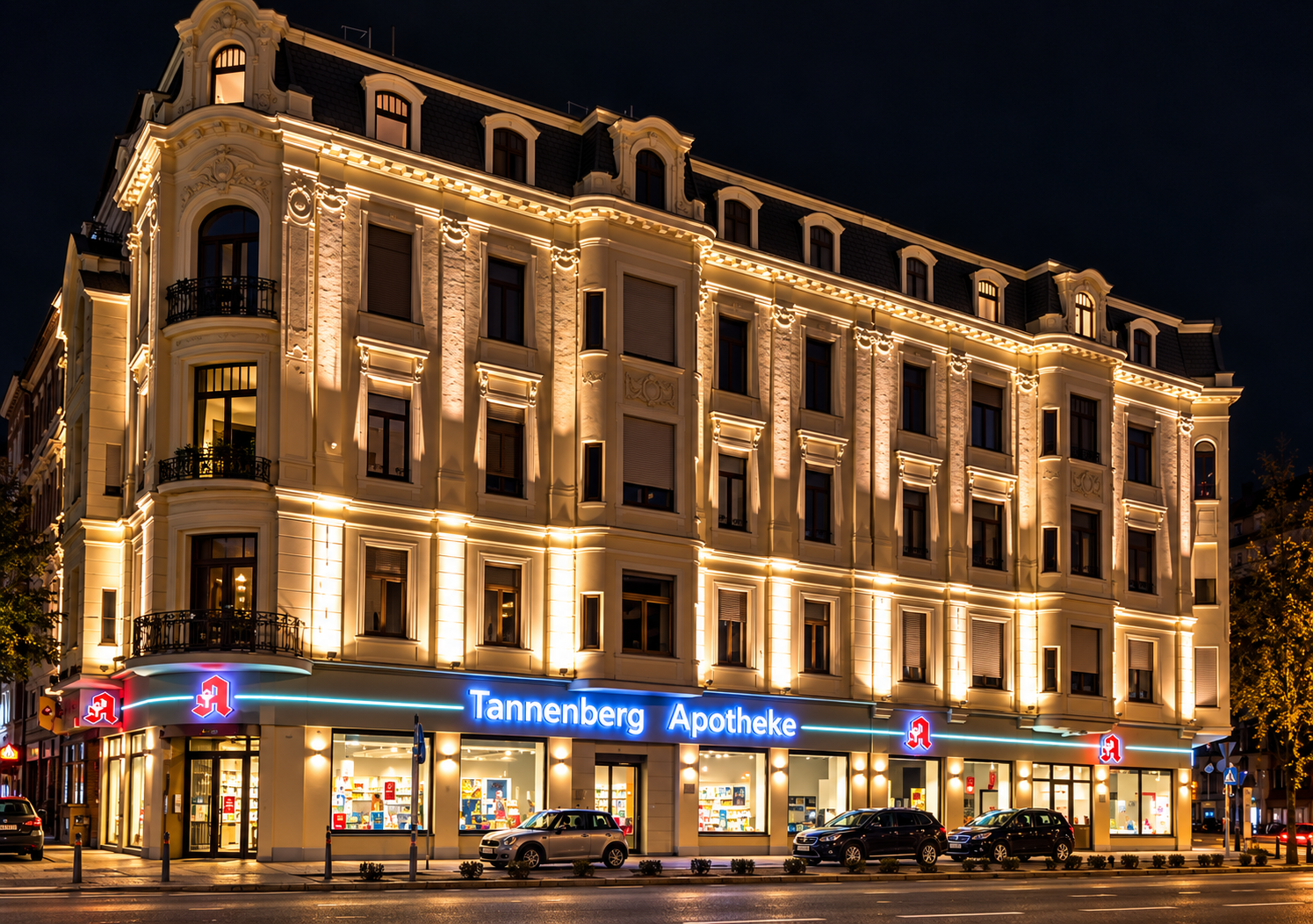 Robert-Daum-Platz 2 mit beleuchteter Schmuckfassade und Apotheke im Erdgeschoss